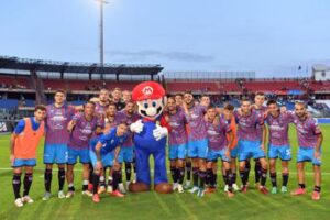 Mario festeggia in campo con il Catania per Super Mario Bros. Wonder