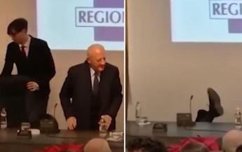 Gli sfilano la sedia e De Luca cade al brindisi di fine anno: la sequenza è virale