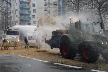 Protesta trattori a Bruxelles, sale la tensione: agricoltori appiccano roghi e polizia usa idranti